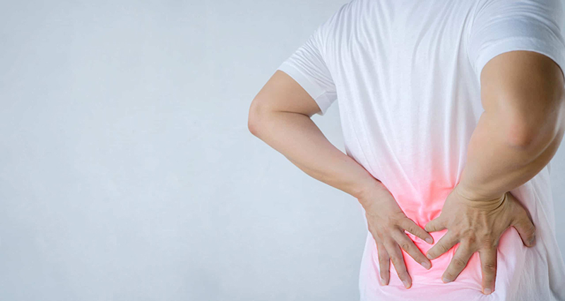 Đau lưng là một trong những triệu chứng phổ biến của người bị viêm cột sống dính khớp