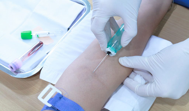 Nhân viên y tế đang tiến hành lấy mẫu máu cho bệnh nhân