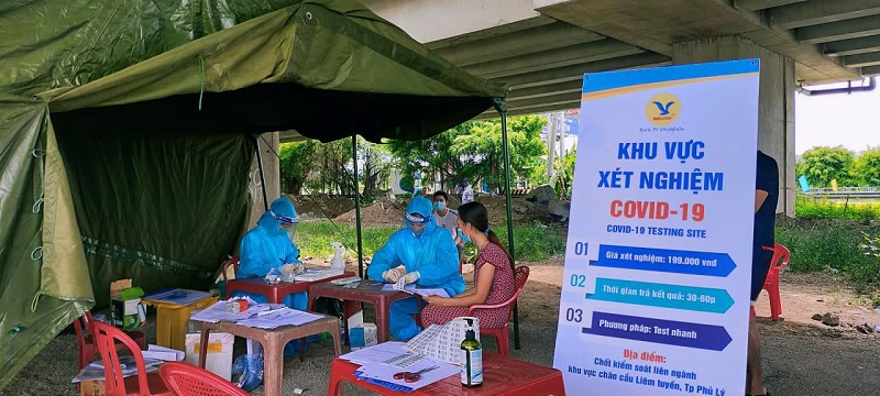 Nhân viên y tế MEDLATEC Hà Nam đang tiến hành lấy mẫu xét nghiệm test nhanh Covid tại một chốt kiểm dịch ở địa phương