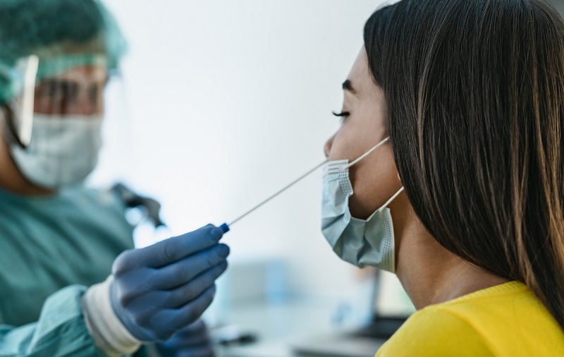 Nhân viên y tế lấy dịch mũi để thực hiện xét nghiệm PCR Covid-19