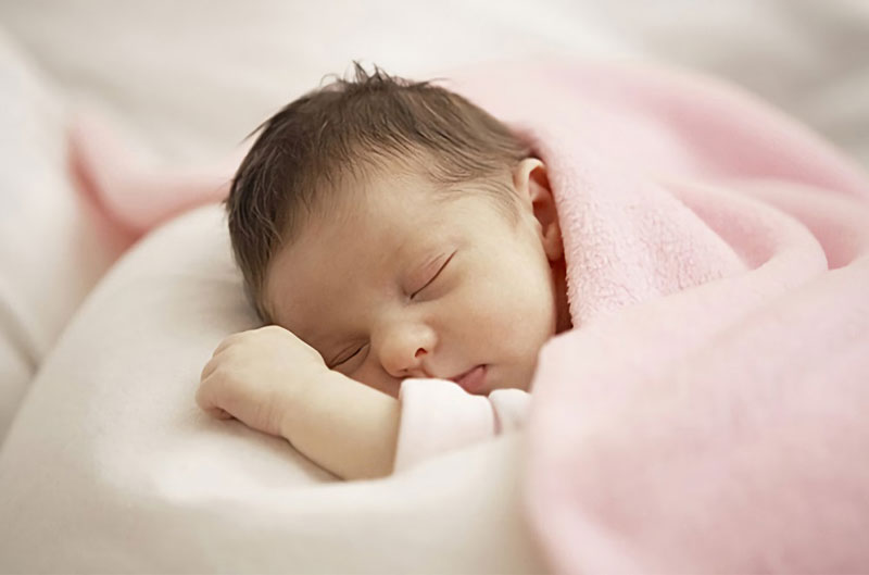 Chuẩn bị chiếc giường với chăn gối êm ái là cách giúp trẻ sơ sinh ngủ ngon