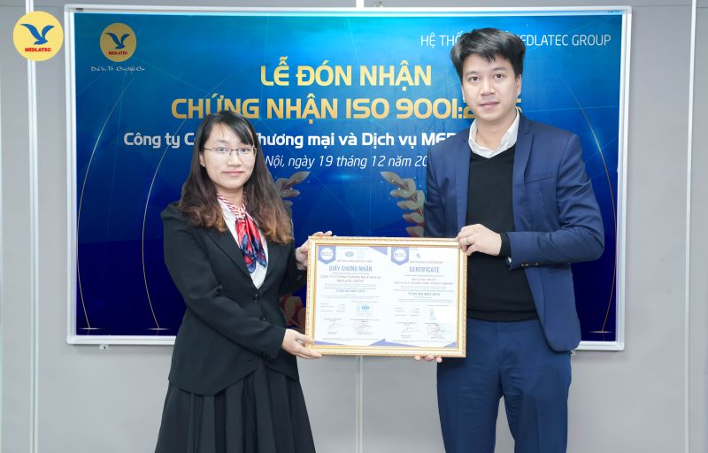 Tổng Giám đốc Nguyễn Trí Anh đại diện MEDLATEC GROUP nhận chứng nhận ISO 9001:2015 từ bà Nguyễn Thùy Dương​ - Giám đốc Văn phòng Công nhận Chất lượng (BQC)