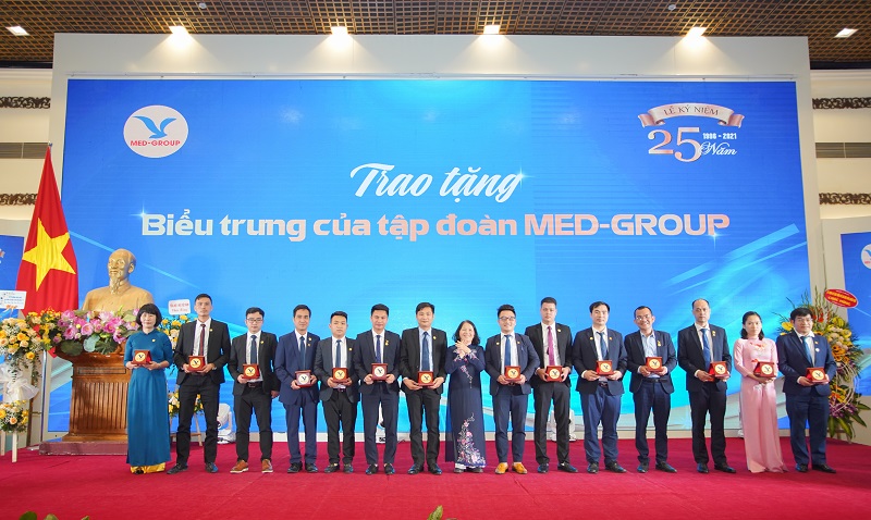 Chủ tịch Hội đồng quản trị Võ Thị Ngọc Lan (đứng giữa) lên lên trao biểu tượng  gắn bó 5 năm tới đại diện CBNV có thâm niên trên 5 năm