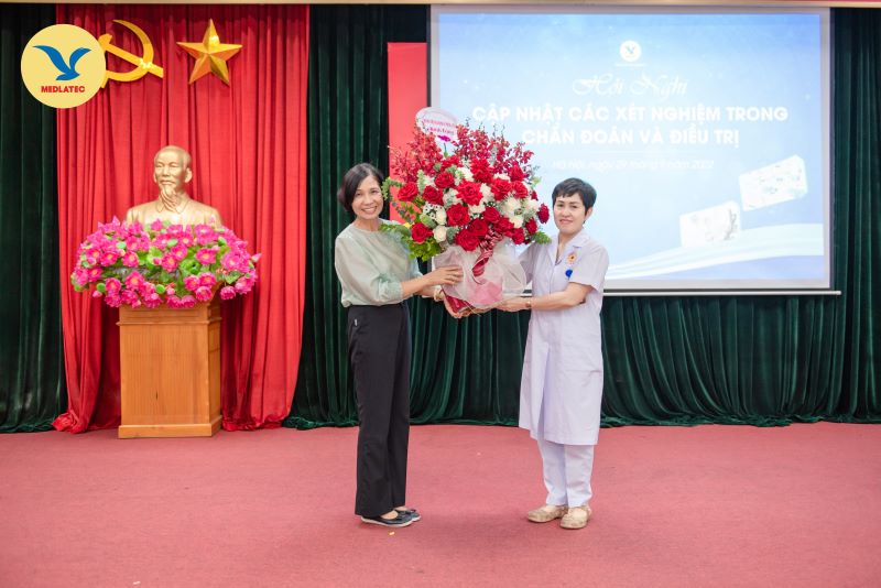 Chủ tọa PGS.TS Hoàng Thị Ngọc Lan tặng hoa đến đại diện Bệnh viện YHCT bộ Công an - BSCKII. Lê Thị Hoài Anh