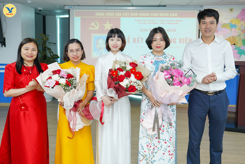  Đồng chí Nguyễn Trí Anh và đồng chí Nguyễn Thị Kim Len trao tặng hoa cho các đảng viên mới