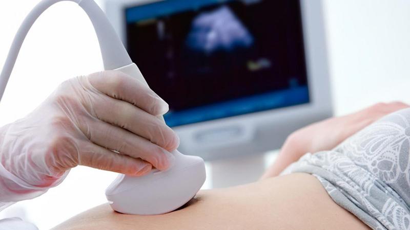Bác sĩ đang siêu âm thai cho mẹ bầu