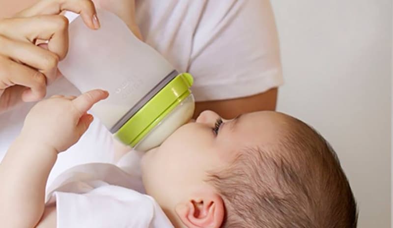 Hệ tiêu hóa bị kích ứng bởi sữa công thức có thể là nguyên nhân khiến trẻ sơ sinh đi ngoài có hạt vàng