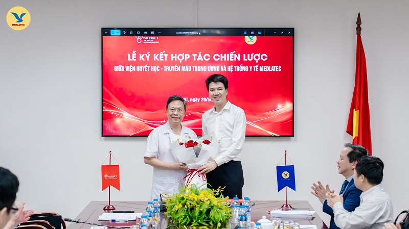 Lãnh đạo hai đơn vị tặng hoa cho nhau bó hoa tươi thắm sau khi lễ ký kết diễn ra thành công tốt đẹp