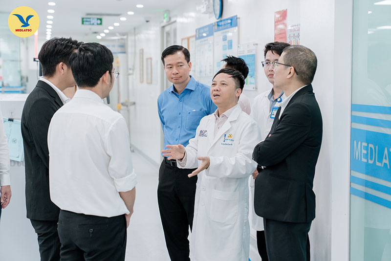PGS.TS Nguyễn Thái Sơn dẫn đoàn đi tham quan các phòng chức năng của Trung tâm Xét nghiệm 