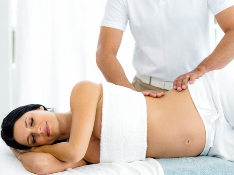 Mẹ bầu có thể tham khảo biện pháp chườm ấm và massage vùng chậu để làm giảm cơn đau 