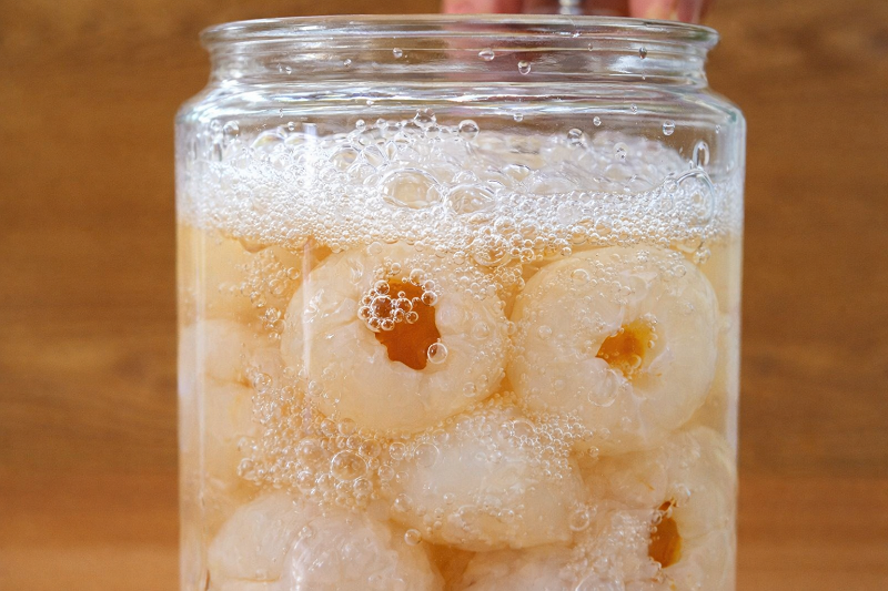 Hũ vải ngâm đường xuất hiện bọt khí li ti trên bề mặt – dấu hiệu khiến nhiều người lo lắng về độ an toàn thực phẩm.