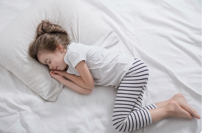 Tư thế ngủ co người, cuộn tròn là một trong các dấu hiệu trẻ bị lạnh khi ngủ