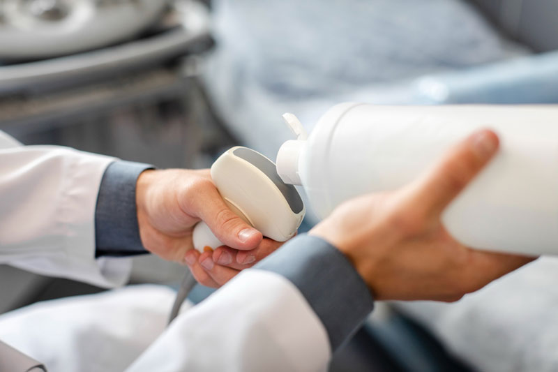 Bác sĩ thoa gel chuyên dụng vào đầu dò trước khi siêu âm cho bệnh nhân