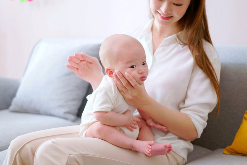 Tư thế cho trẻ ngồi trên đùi và vỗ ợ hơi