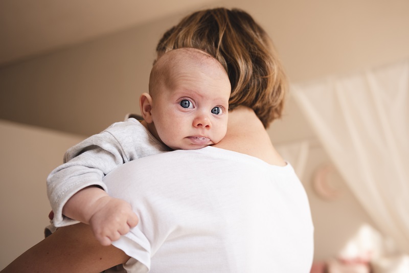 Hình ảnh mô phỏng cách vỗ ợ hơi cho trẻ sơ sinh ở tư thế bế tựa trên vai