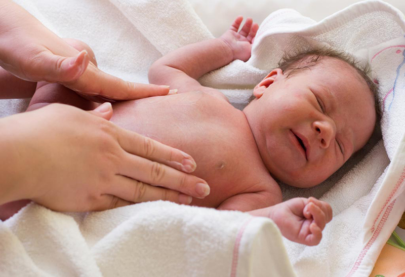 Có những biểu hiện nào khác kèm theo bụng cứng ở trẻ sơ sinh?
